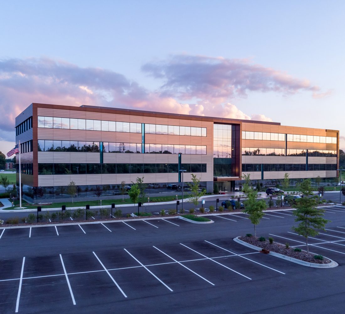 Evening shot of office building exterior with large parking lot